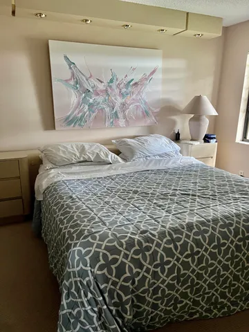 a large bed sitting in a bedroom next to a bathroom sink