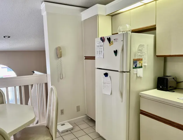a white refrigerator freezer and a table in a kitchen