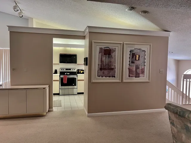 a view of a hallway with workspace and a window