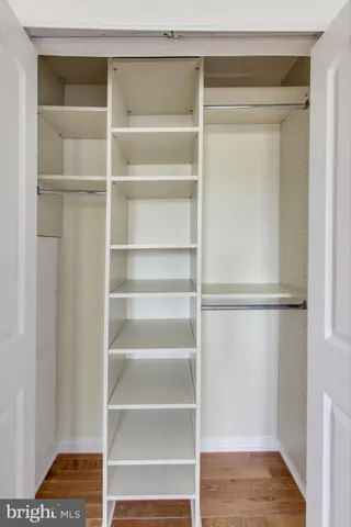 a view of walk in closet with empty racks