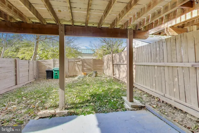 a view of a yard with wooden fence