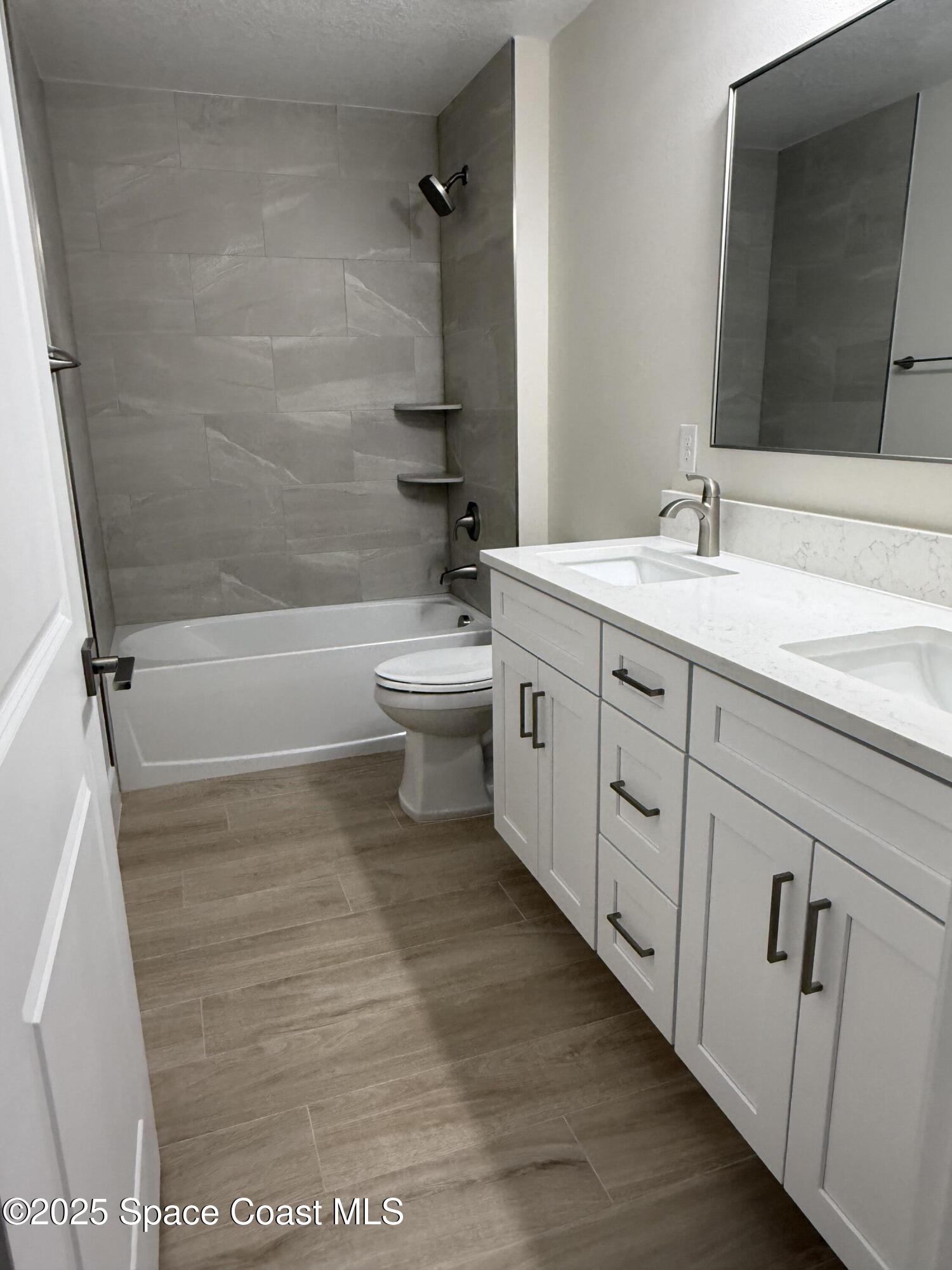 581 Toynbee Road Palm Bay, FL 32908 - Photo 21 of 25 a bathroom with a double vanity sink toilet and shower