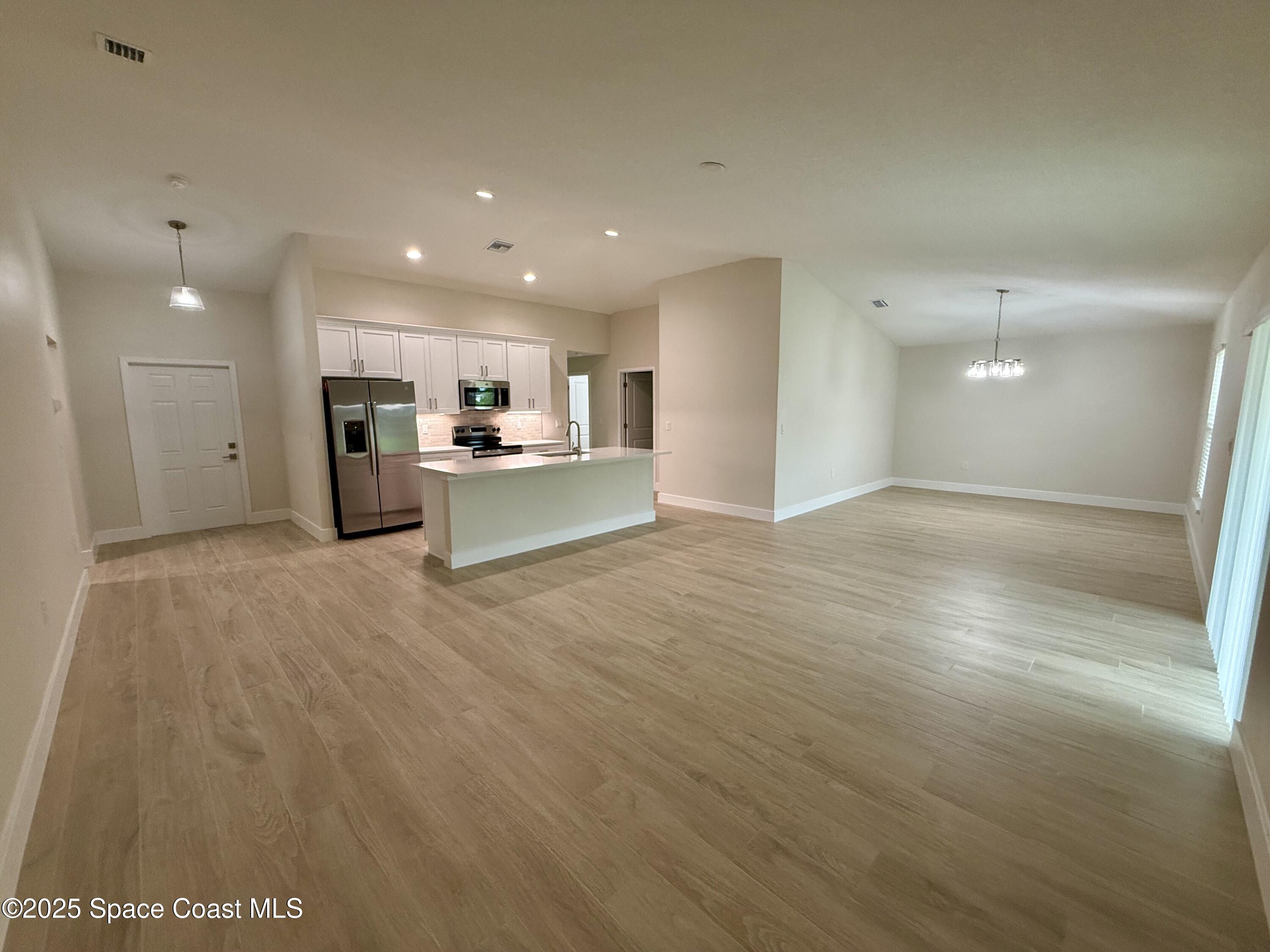 581 Toynbee Road Palm Bay, FL 32908 - Photo 3 of 25 a view of a kitchen with a sink and a refrigerator
