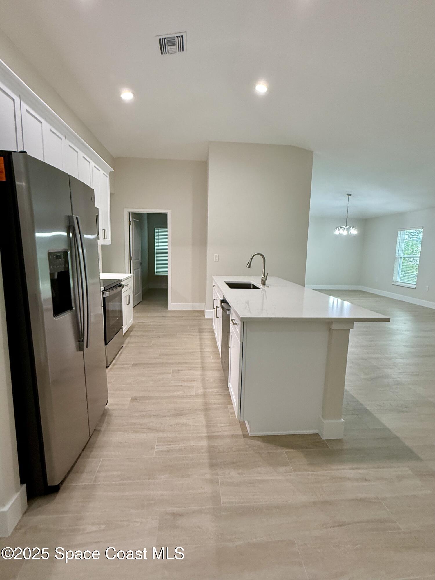 581 Toynbee Road Palm Bay, FL 32908 - Photo 8 of 25 a large kitchen with stainless steel appliances granite countertop a refrigerator a sink a stove and a refrigerator