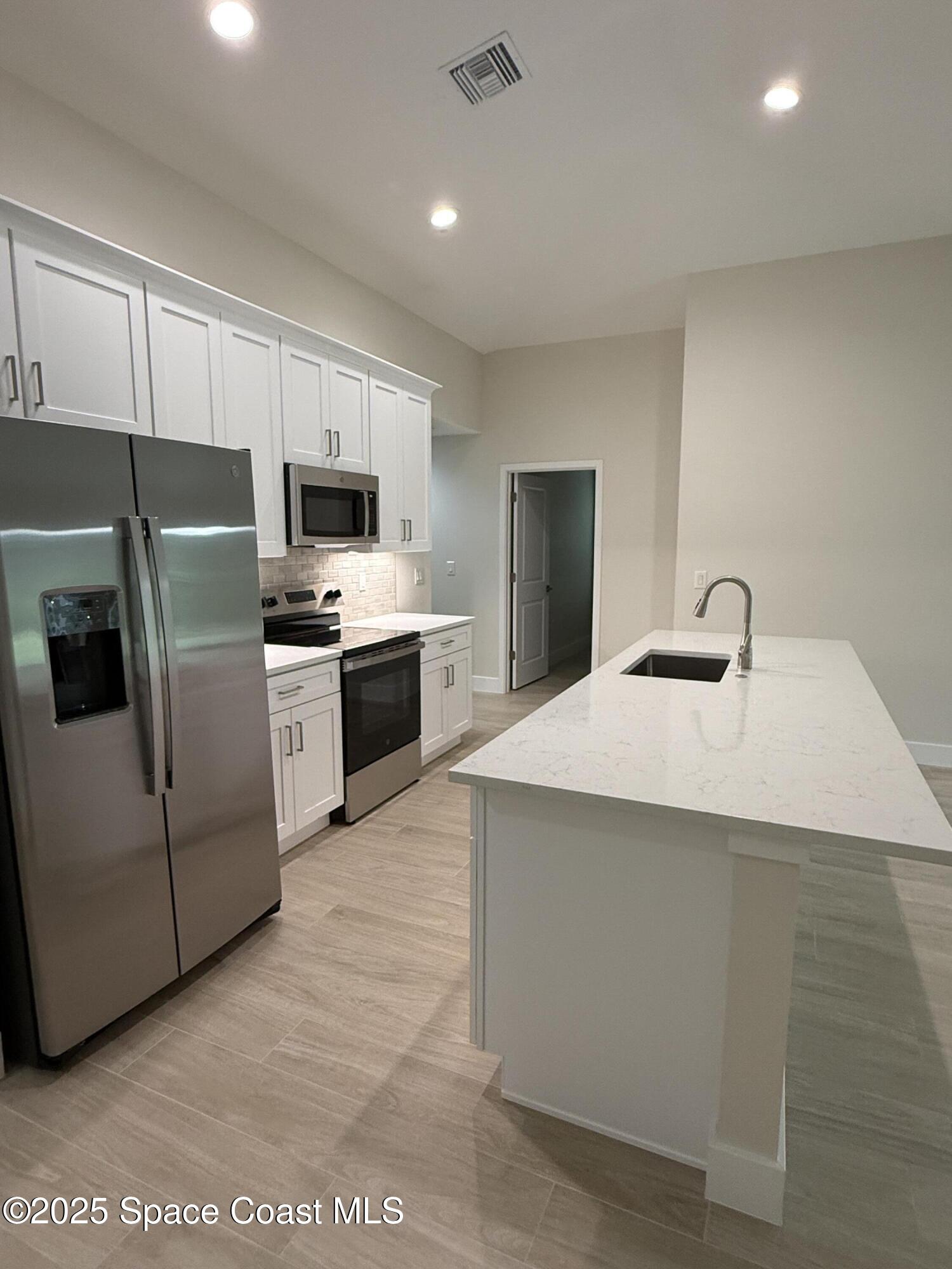 581 Toynbee Road Palm Bay, FL 32908 - Photo 9 of 25 a kitchen with cabinets and stainless steel appliances