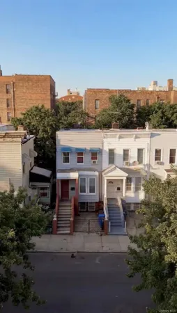 a view of a white building among the street and tall buildings