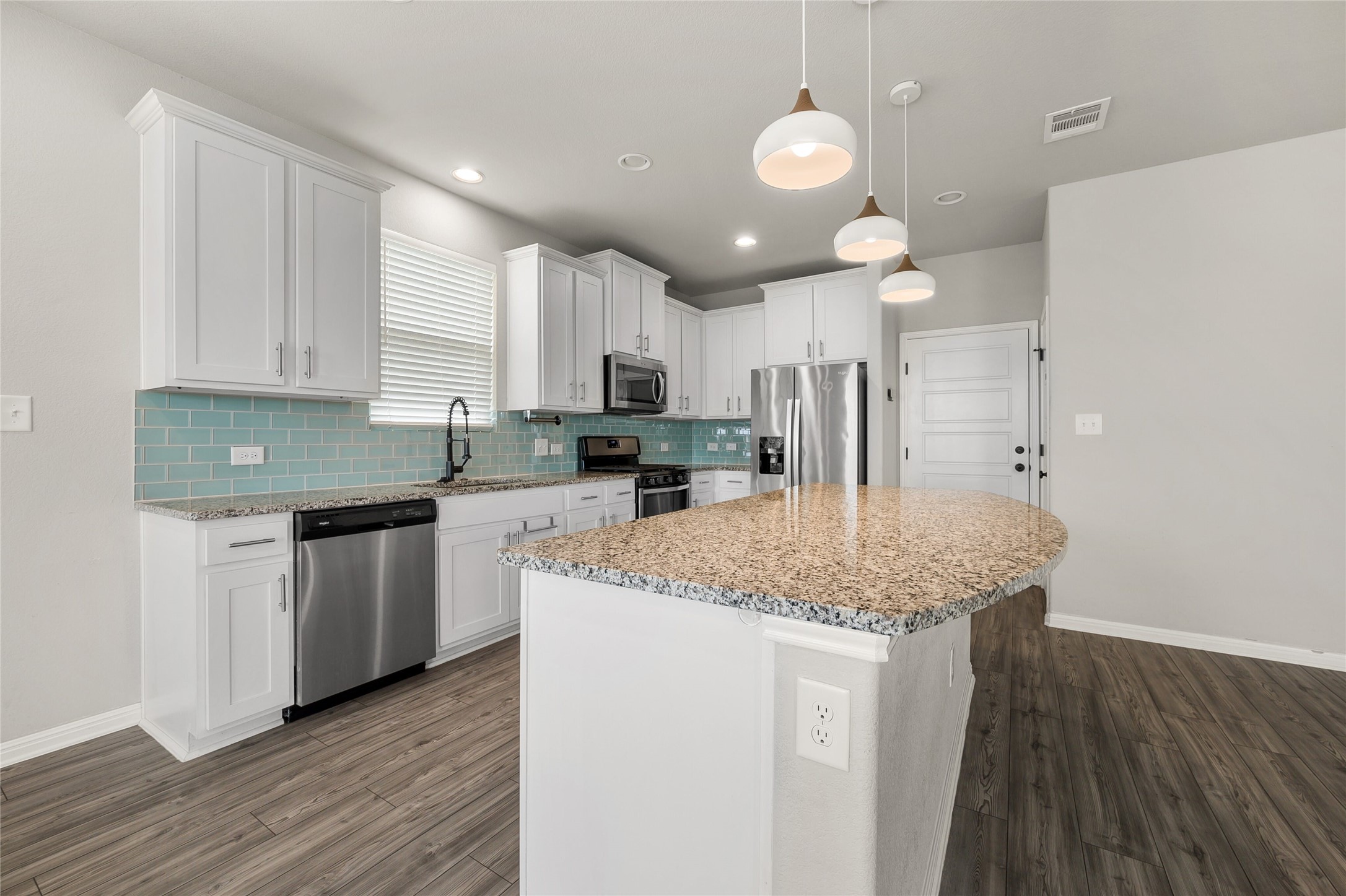 101 Lambert Street Leander, TX 78641 - Photo 9 of 33 Granite counters and stainless steel appliances adorn this well-appointed kitchen.