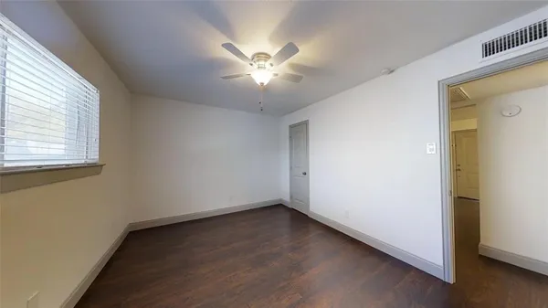 a view of a room with wooden floor and a ceiling fan