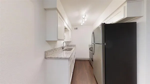 a kitchen with a refrigerator and a sink