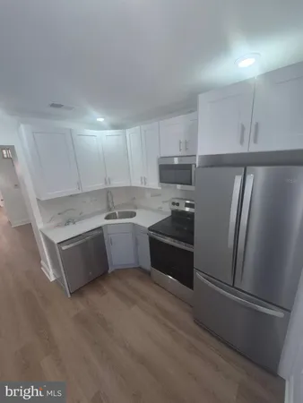 a kitchen with a refrigerator sink and cabinets