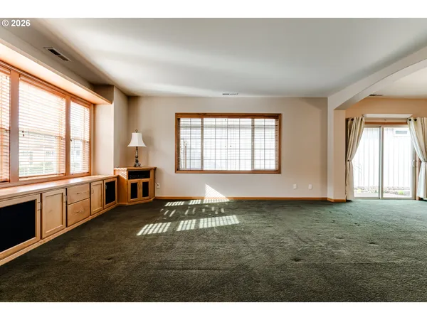 a living room with furniture and a open kitchen view