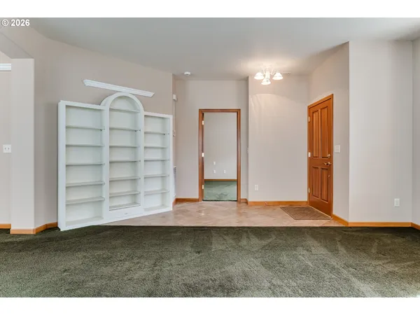 a view of an empty room with wooden floor and cabinet