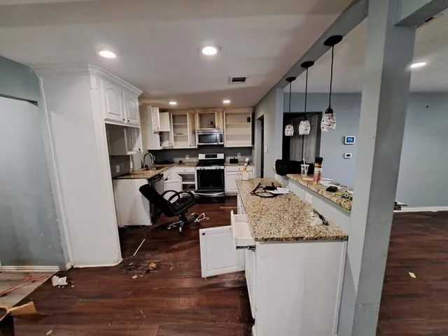 a kitchen with sink refrigerator and cabinets