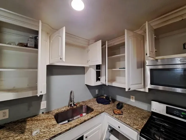 a kitchen with a sink stove and cabinets