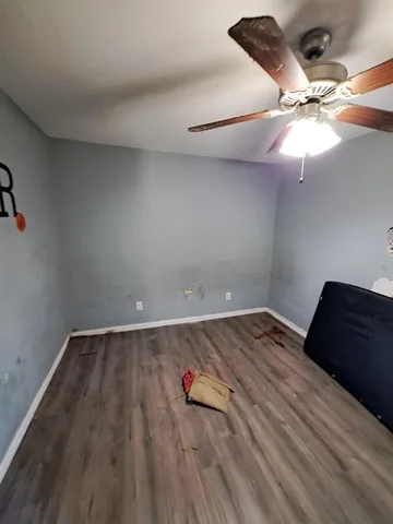 a view of a room with wooden floor and ceiling fan