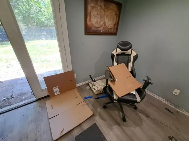 a view of a workspace with furniture and a window