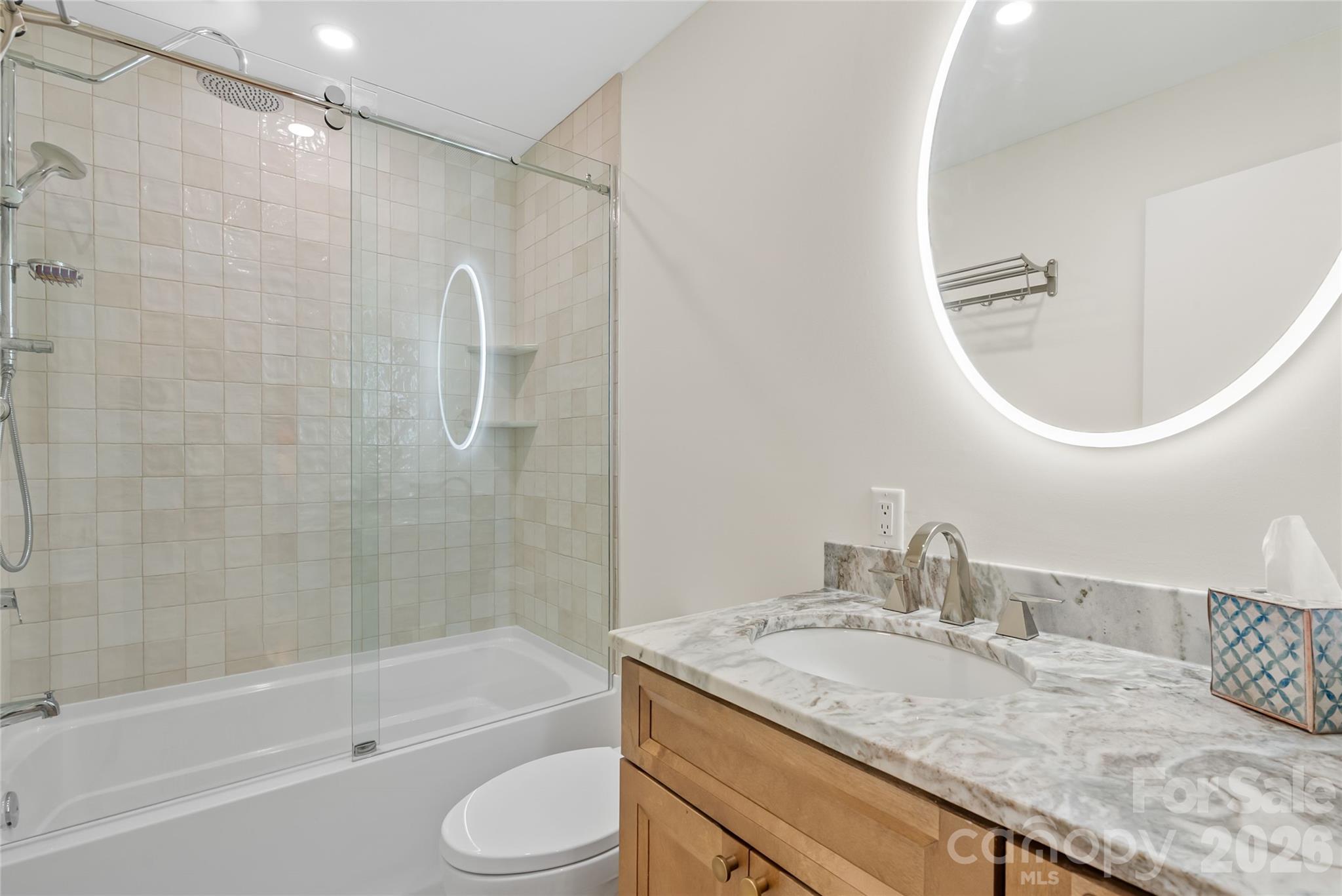 132 Snelson Cemetary Road Leicester, NC 28748 - Photo 17 of 34 a bathroom with a granite countertop sink a toilet and bathtub