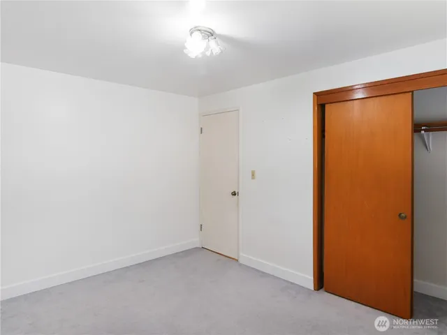 an empty room with a window and a ceiling fan