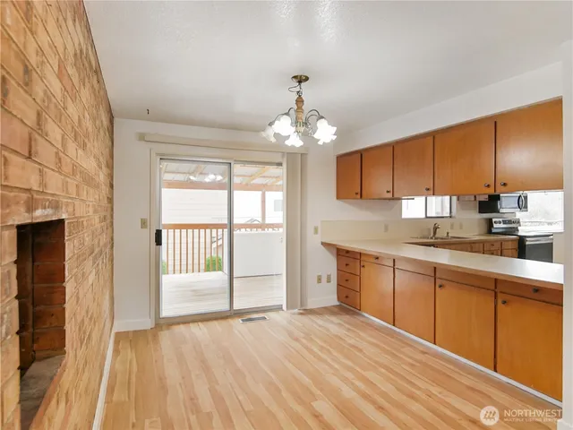 a open kitchen with granite countertop a sink dishwasher a stove and a refrigerator with wooden floor