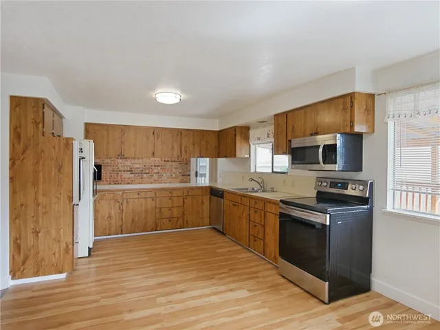 a kitchen with granite countertop a stove top oven sink and cabinets