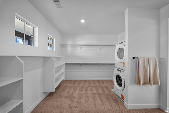 382 North Rhyolite Drive, Unit 111 Hurricane, UT 84737 - Photo 13 of 37 Walk-in closet with integrated shelving, multiple windows, built-in clothing rods, and stacked laundry appliances