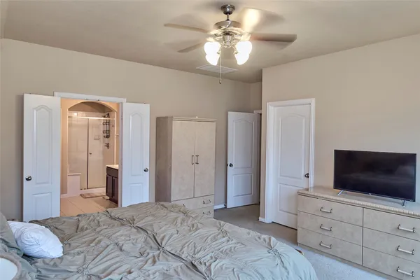 a bedroom with a bed and a flat screen tv