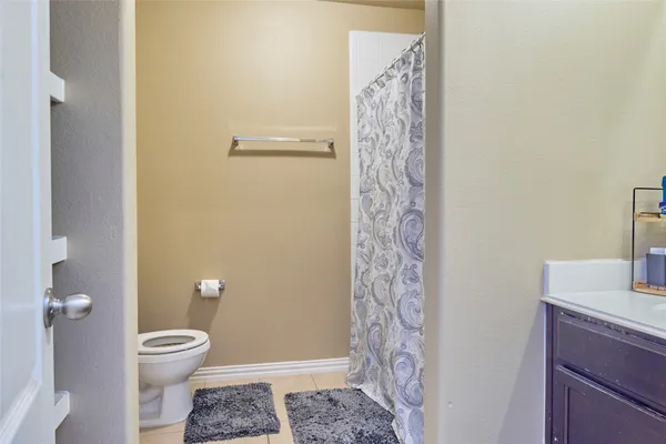 a bathroom with a granite countertop shower and a toilet