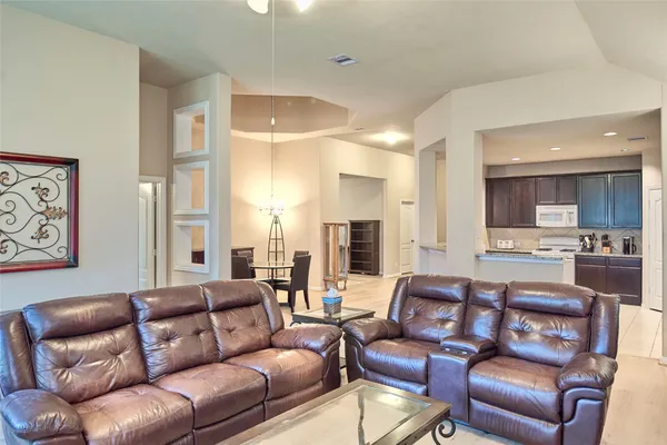 a living room with furniture a couch and kitchen view