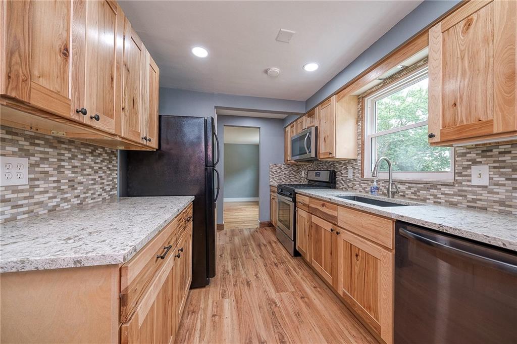 1015 McNeilly Road Pittsburgh, PA 15226 - Photo 10 of 29 a kitchen with stainless steel appliances granite countertop a sink a stove and a wooden floors
