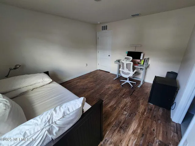 a bedroom with a bed and a closet with wooden floor