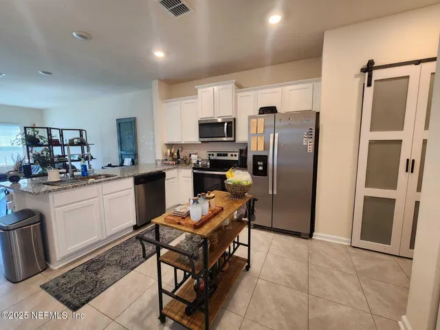 a kitchen with kitchen island a stove a sink dishwasher a refrigerator and microwave with wooden floor