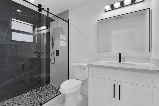 a bathroom with a sink a toilet and shower