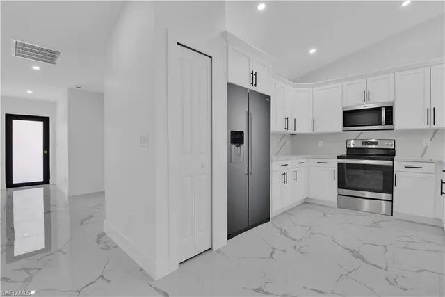 a kitchen with stainless steel appliances a refrigerator sink and cabinets