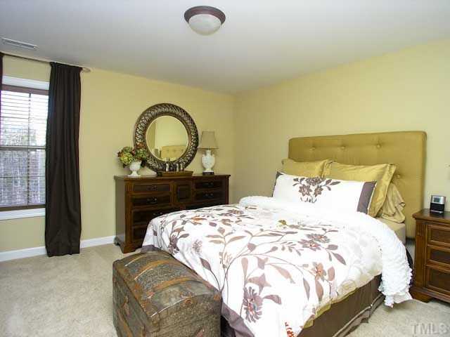 421 Rensford Place Cary, NC 27513 - Photo 16 of 25 a bedroom with a bed and a painting on the wall