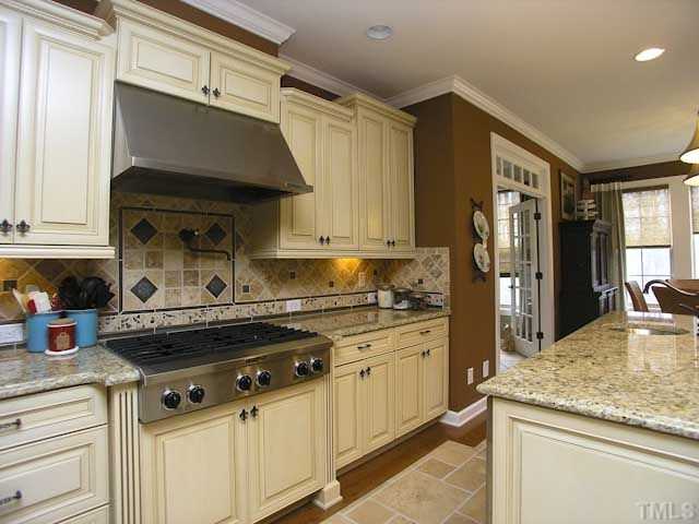 421 Rensford Place Cary, NC 27513 - Photo 8 of 25 a kitchen with stainless steel appliances granite countertop a sink a stove and a refrigerator