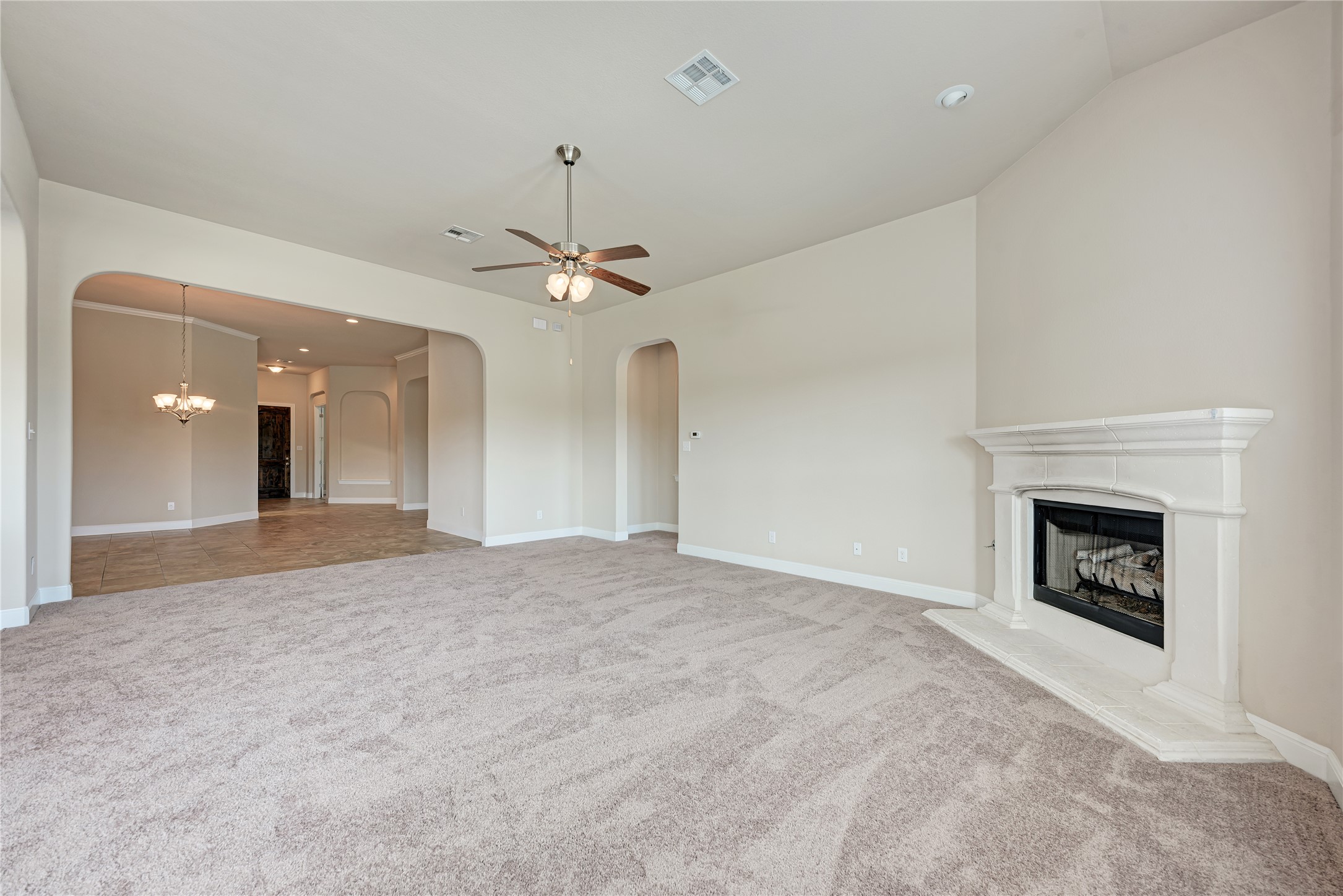 600 Rosedale Boulevard Georgetown, TX 78628 - Photo 10 of 28 A comfortable living space boasts a classic fireplace and broad arched doorways, creating an inviting flow.