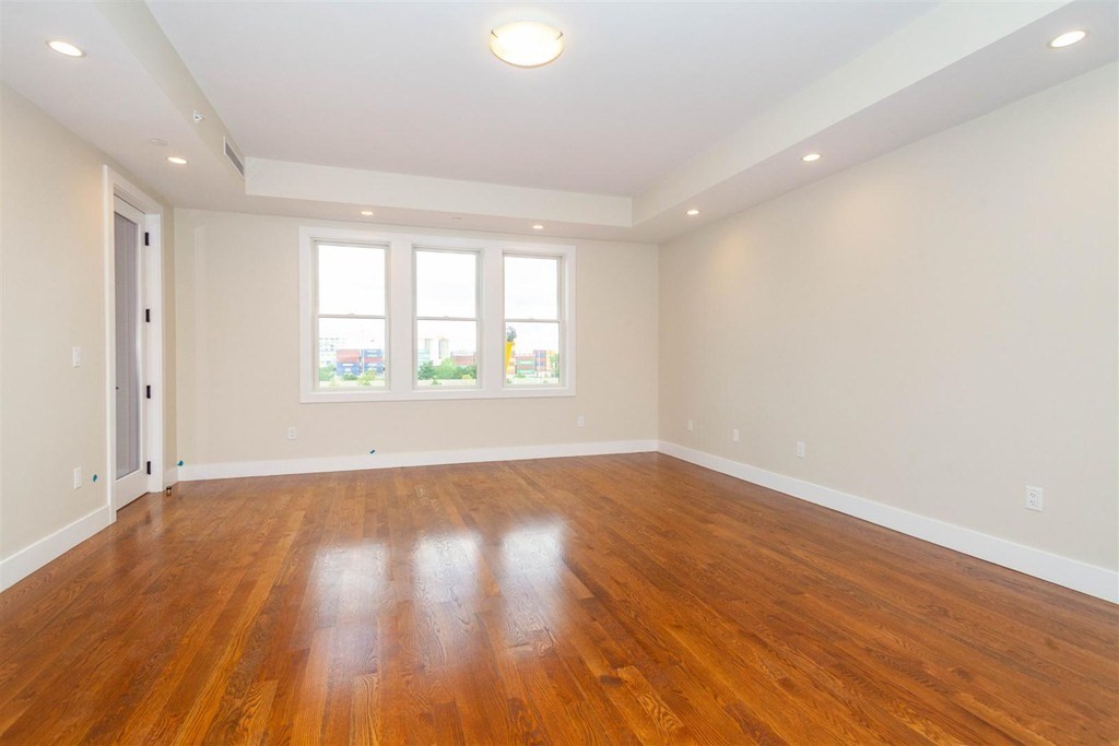 906 East 2nd Street, Unit 106 Boston, MA 02127 - Photo 7 of 14 an empty room with wooden floor and windows