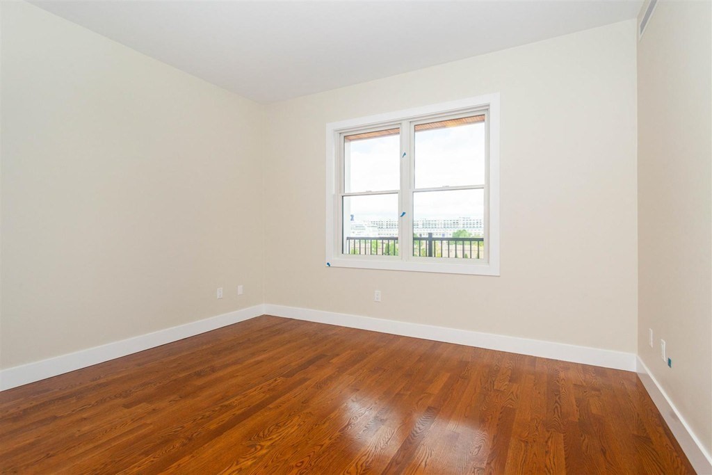 906 East 2nd Street, Unit 106 Boston, MA 02127 - Photo 10 of 14 an empty room with wooden floor and windows