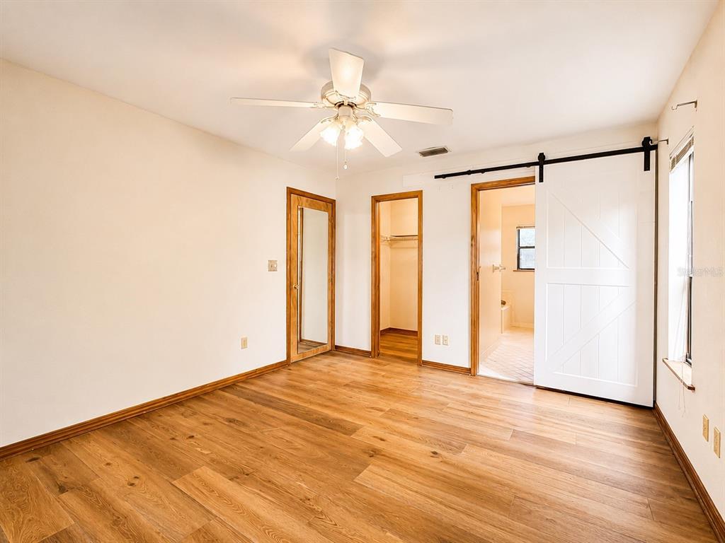 7119 Immokalee Road Keystone Heights, FL 32656 - Photo 19 of 50 a view of an empty room with wooden floor and a window