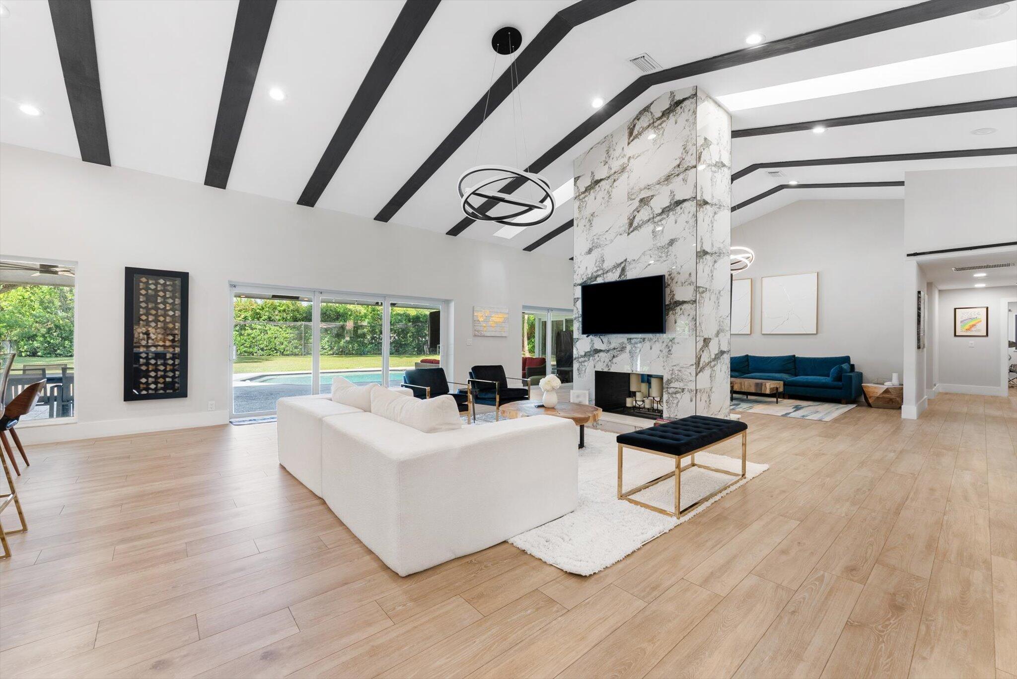 4429 Woodfield Boulevard Boca Raton, FL 33434 - Photo 13 of 61 a living room with patio fireplace furniture and a flat screen tv