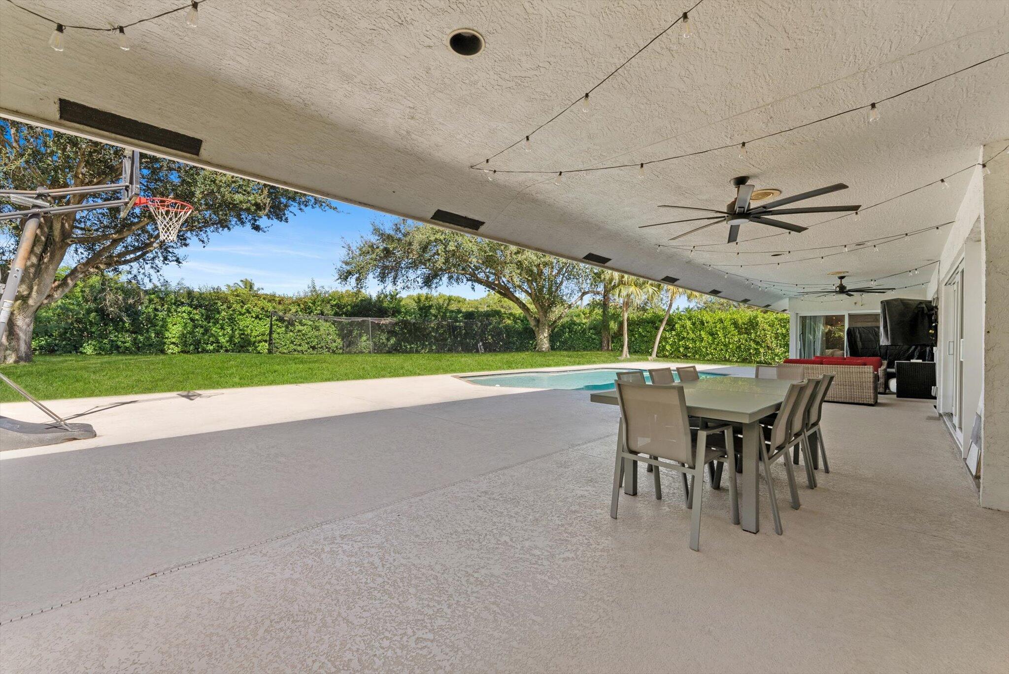 4429 Woodfield Boulevard Boca Raton, FL 33434 - Photo 39 of 61 a view of a patio with a table and chairs