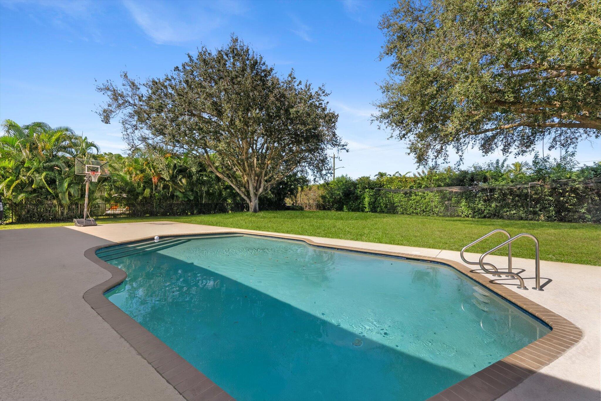 4429 Woodfield Boulevard Boca Raton, FL 33434 - Photo 42 of 61 a view of a swimming pool with a yard