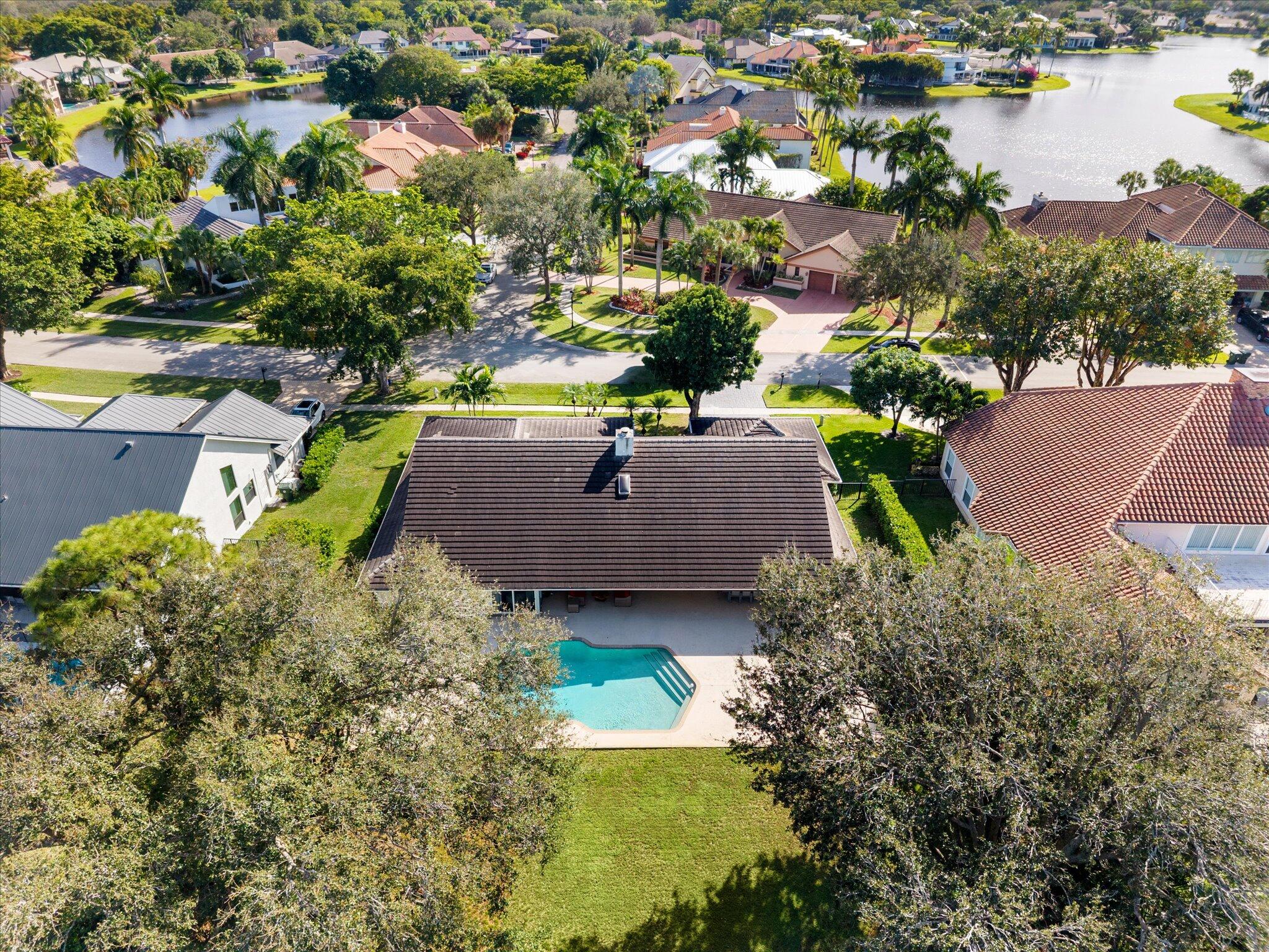 4429 Woodfield Boulevard Boca Raton, FL 33434 - Photo 49 of 61 an aerial view of a house with a garden and lake view