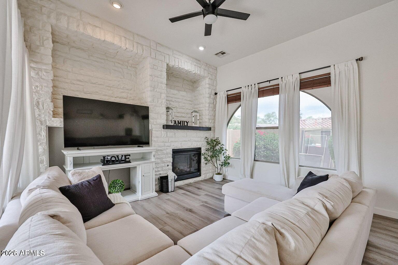 3950 North Edith Way Buckeye, AZ 85396 - Photo 14 of 32 a living room with furniture a flat screen tv and a fireplace