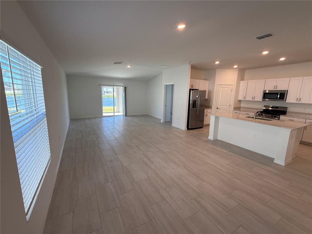 12434 Radiant Crystal Rose Place Parrish, FL 34219 - Photo 3 of 39 a view of a kitchen with a sink cabinets and a window
