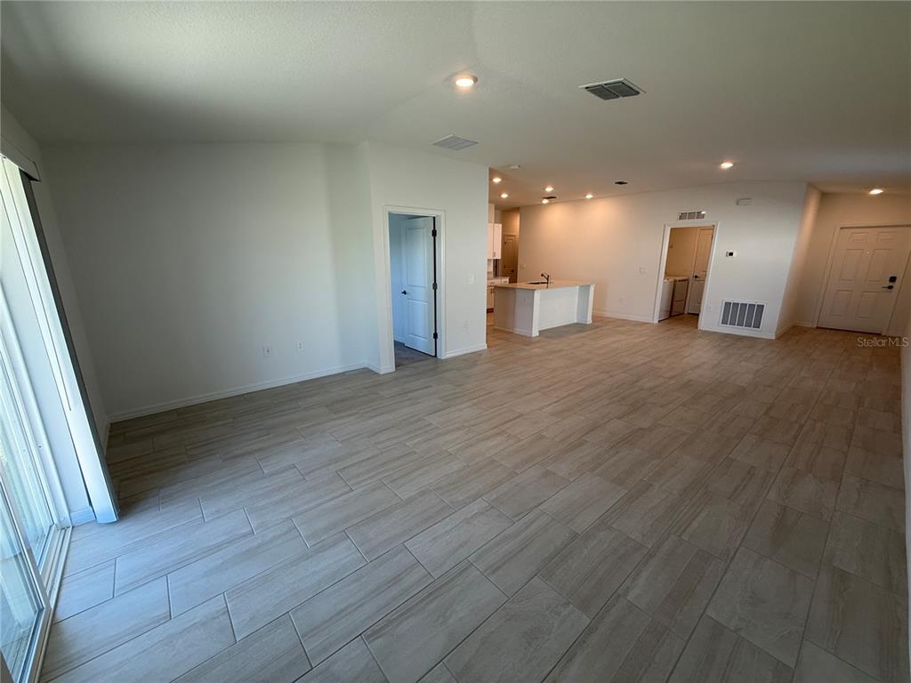 12434 Radiant Crystal Rose Place Parrish, FL 34219 - Photo 6 of 39 an empty room with wooden floor and windows