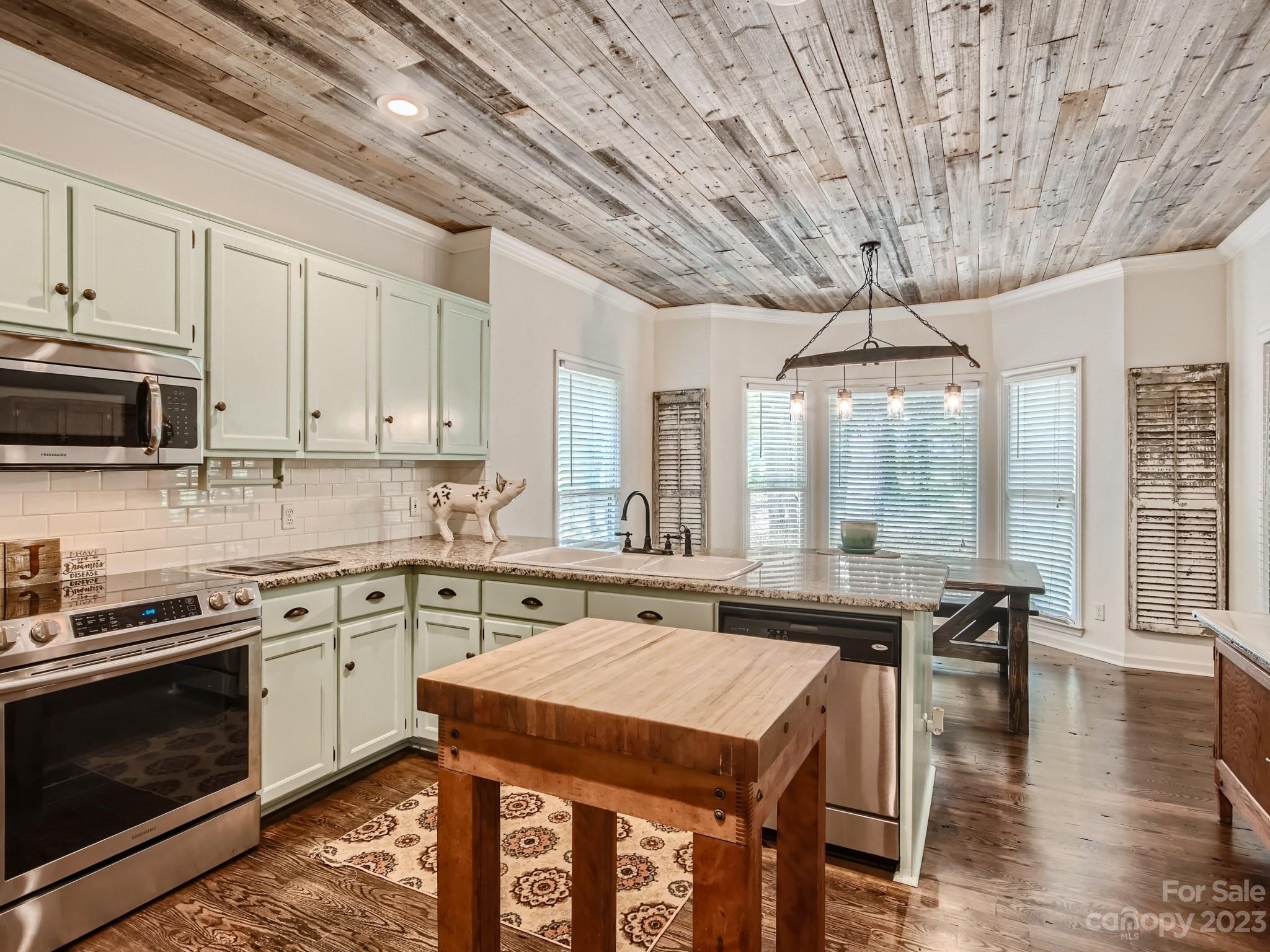 1815 Rock Rest Road Wingate, NC 28174 - Photo 9 of 27 a kitchen with stainless steel appliances granite countertop a stove a refrigerator a sink a dining table and chairs with wooden floor