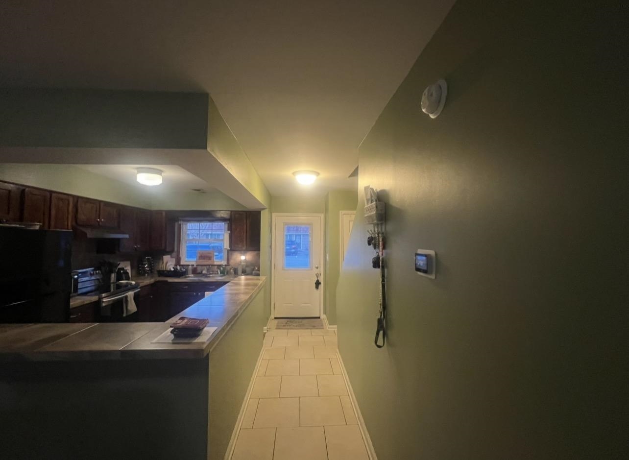 1025 Carolina Road, Unit O1 Conway, SC 29526 - Photo 7 of 18 Kitchen featuring tile counters, stainless steel range with electric stovetop, freestanding refrigerator, dark brown cabinetry, and light tile patterned floors