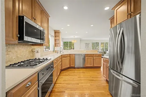 a large kitchen with a large counter top space appliances and cabinets