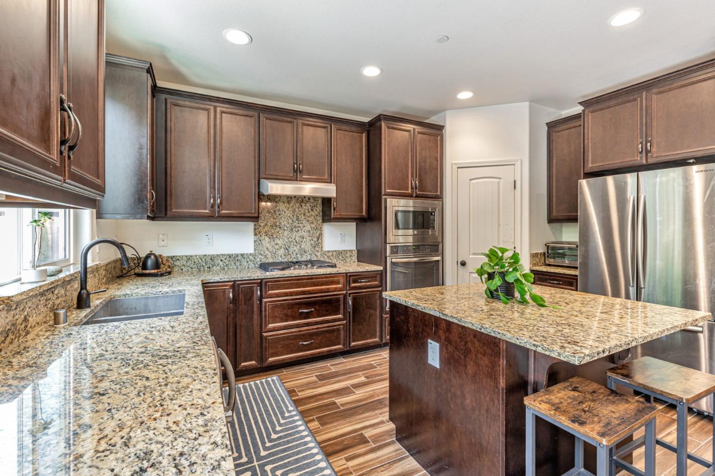 51 Koror Lane Gilroy, CA 95020 - Photo 8 of 50 a kitchen with stainless steel appliances granite countertop a stove refrigerator sink and cabinets